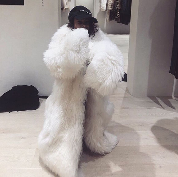 North West wearing a faux fur coat.