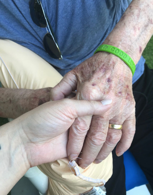 Meghan McCain holding her late father's hand.