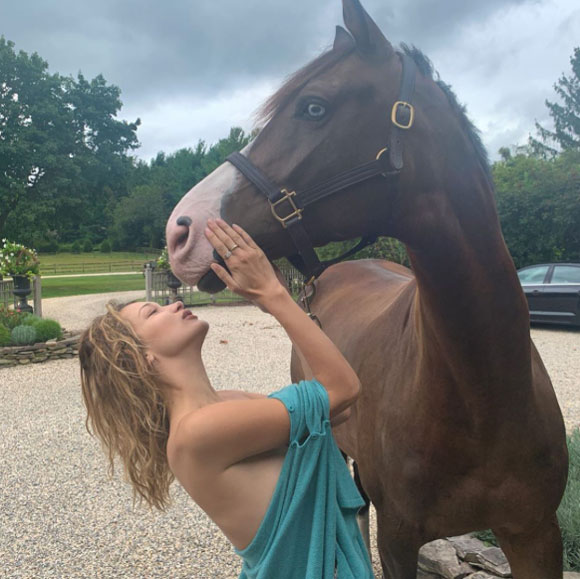 Bella Hadid caresses a gorgeous horse!